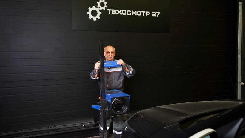 На этой фотографии вы увидите Дмитрия Терещенко, технического эксперта станции техосмотра, занятого проверкой автомобильных систем с помощью диагностических приборов.